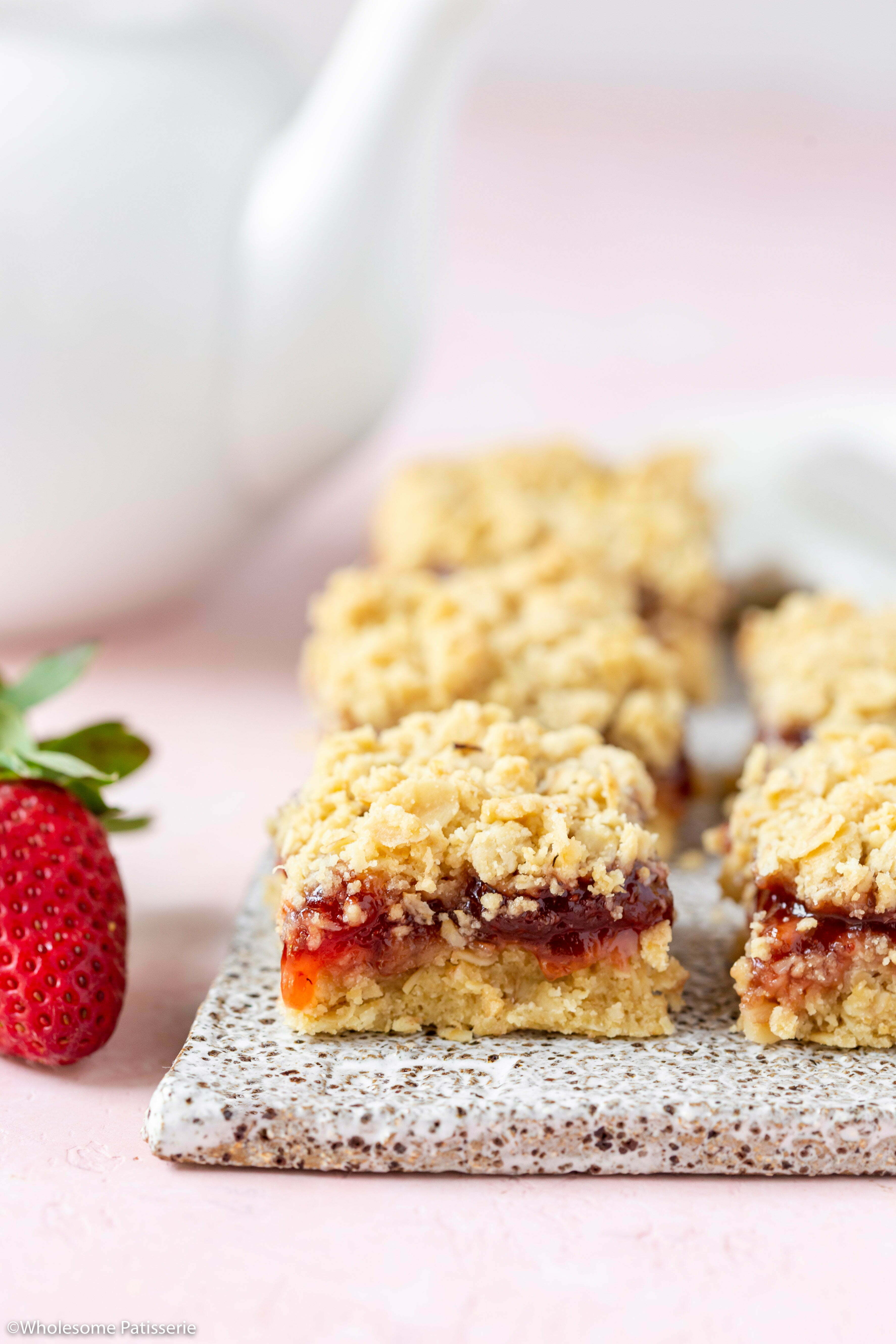 A close up image of one of the bars showing the strawberry jam oozing from the middle. 