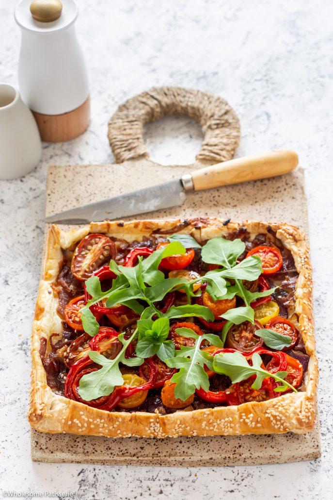 Caramelised Onion Tomato & Capsicum Tart! A fabulous tart to serve over the festive season! The caramelised onions add depth of flavour whilst the cherry tomatoes and capsicum add freshness and texture! Topped with rocket and basil creating a delicious homemade pastry tart everyone will enjoy!