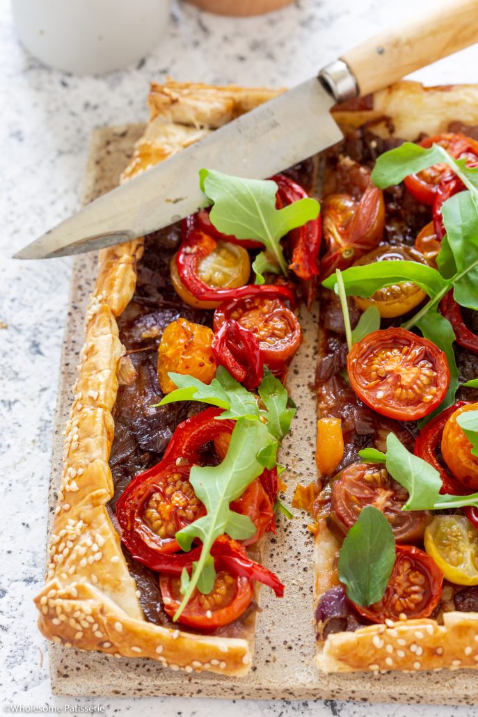 Caramelised Onion Tomato & Capsicum Tart! A fabulous tart to serve over the festive season! The caramelised onions add depth of flavour whilst the cherry tomatoes and capsicum add freshness and texture! Topped with rocket and basil creating a delicious homemade pastry tart everyone will enjoy!