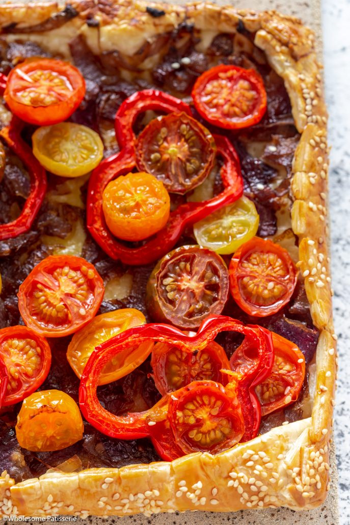 Caramelised Onion Tomato & Capsicum Tart! A fabulous tart to serve over the festive season! The caramelised onions add depth of flavour whilst the cherry tomatoes and capsicum add freshness and texture! Topped with rocket and basil creating a delicious homemade pastry tart everyone will enjoy!