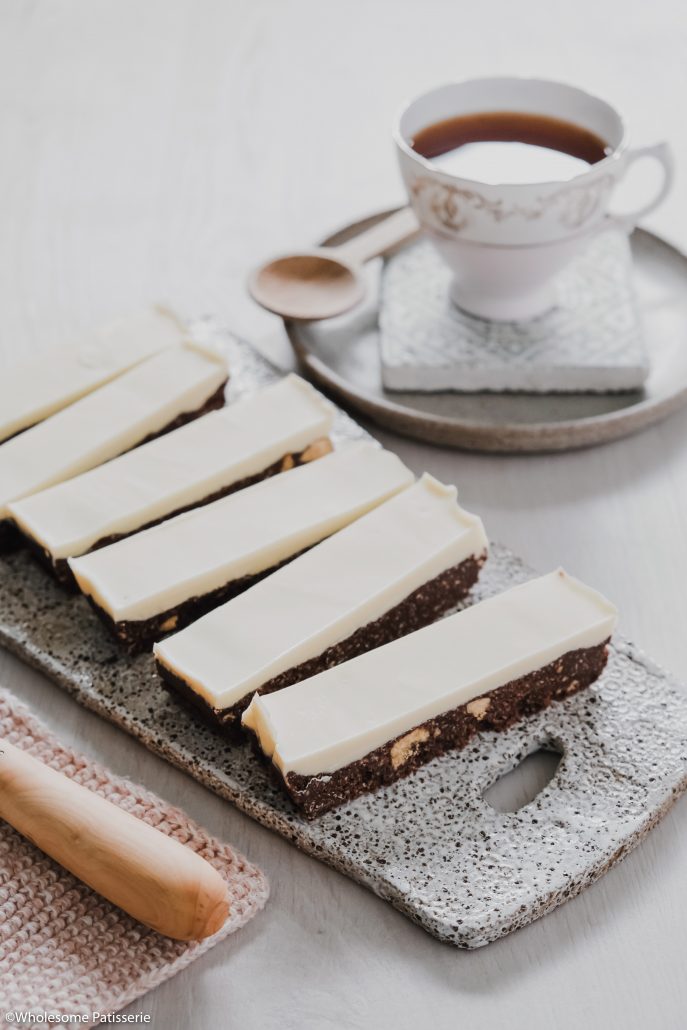 White Chocolate Thin Mint Slice! This delightful slice is no-bake and infused with peppermint essential oil in both the base and topping. The chocolate base is a simple 5-ingredient biscuit mixture using Dutch cocoa powder and peppermint oil. The topping is only 2-ingredients, white chocolate and more peppermint!