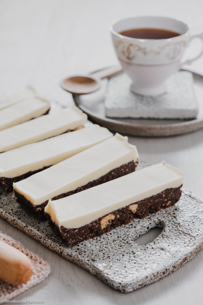 White Chocolate Thin Mint Slice! This delightful slice is no-bake and infused with peppermint essential oil in both the base and topping. The chocolate base is a simple 5-ingredient biscuit mixture using Dutch cocoa powder and peppermint oil. The topping is only 2-ingredients, white chocolate and more peppermint!