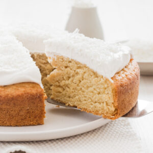 A slice being taken out of this vegan coconut cake recipe.