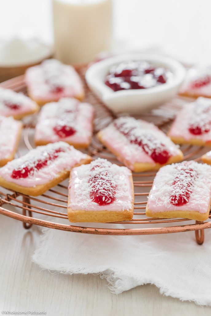 Iced Vovo Biscuits! Delicious biscuits topped with a marshmallow icing, a spread of raspberry jam and a sprinkle of desiccated coconut. These classic Australian biscuits will remind many of their childhoods. They’re oh so sweet and a wonderful treat to enjoy. 