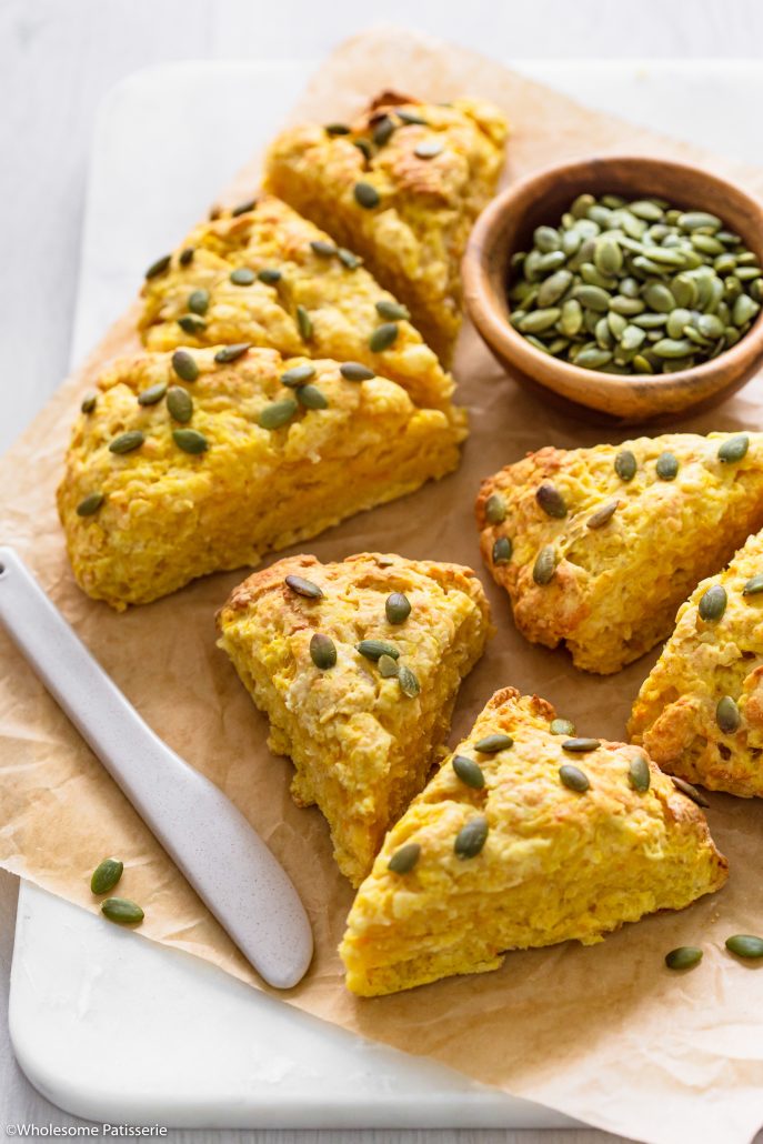 These Cheesy Pumpkin Scones have buttery flakey layers infused with grated cheese and smooth pumpkin. The combination of a crisp crust and fluffy middle makes each mouthful as delicious as the next. Sprinkled with pumpkin seeds and served warm with a spread of butter, these pumpkin scones are perfect for breakfast or afternoon tea. 