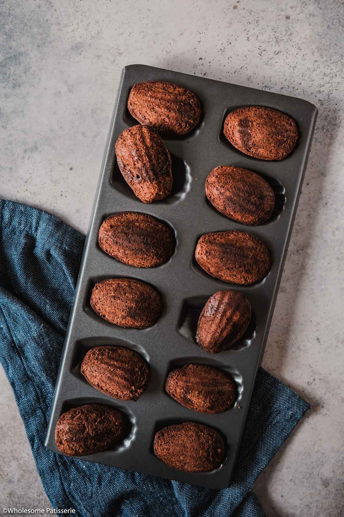 Baked madeleines displayed in the pan