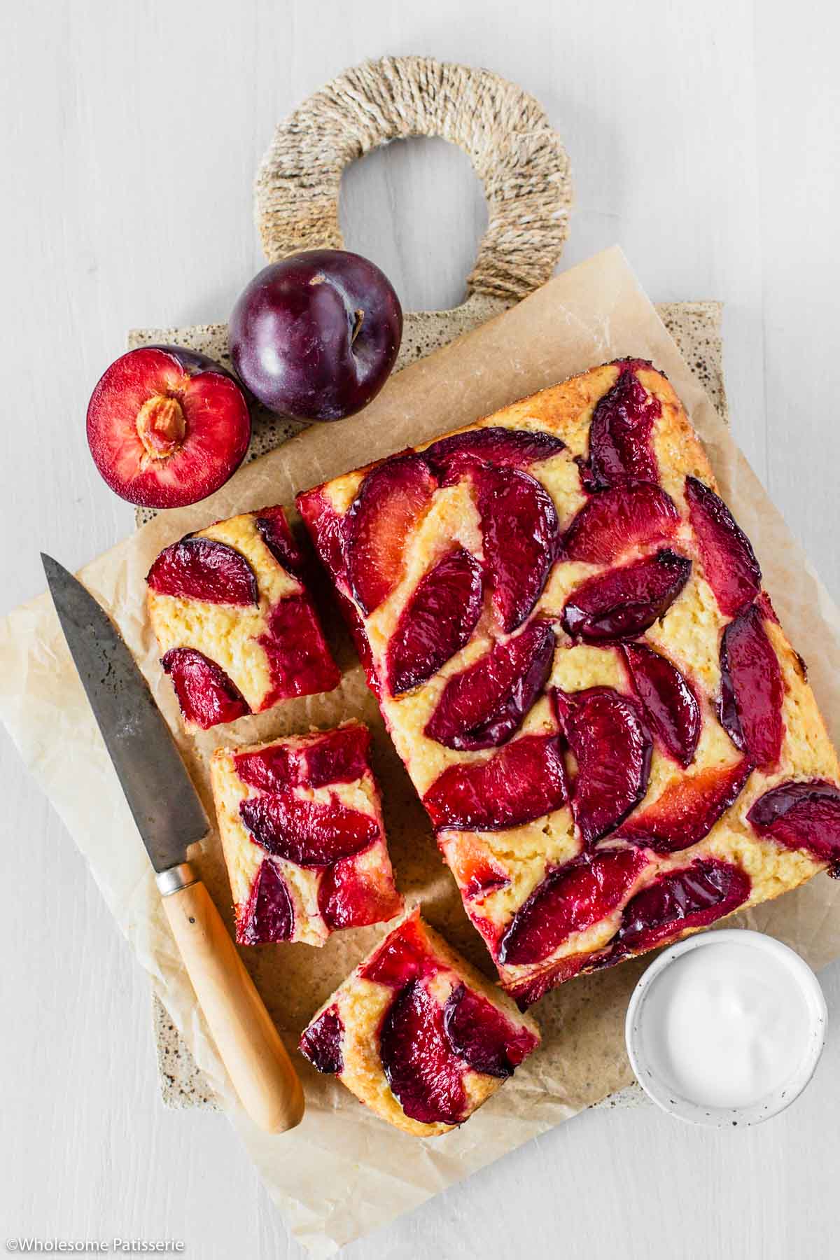 Overhead image of plum cake with slices taken out