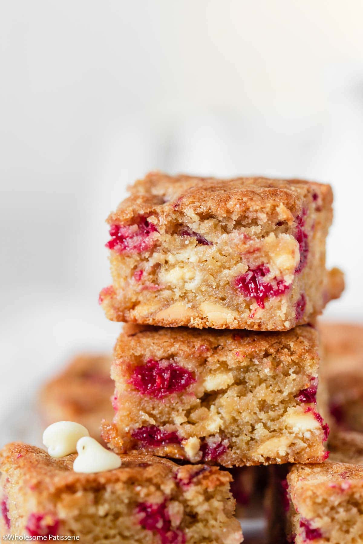 Close up shot of one blondie slice showing the texture, raspberries and chocolate chips