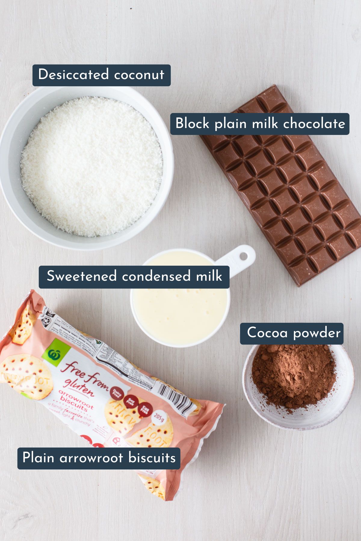 To make this recipe you need desiccated coconut, block of milk chocolate, sweetened condensed milk, cocoa powder and plain arrowroot biscuits.