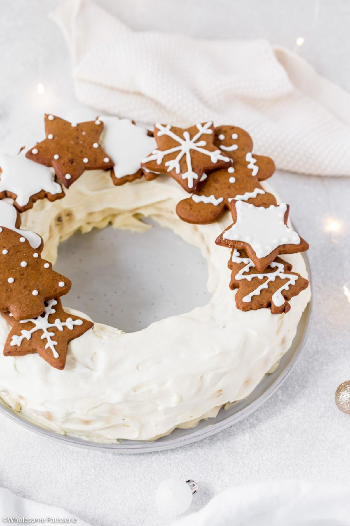 Placing the decorated gingerbread cookies on top of the ripple wreath cake.