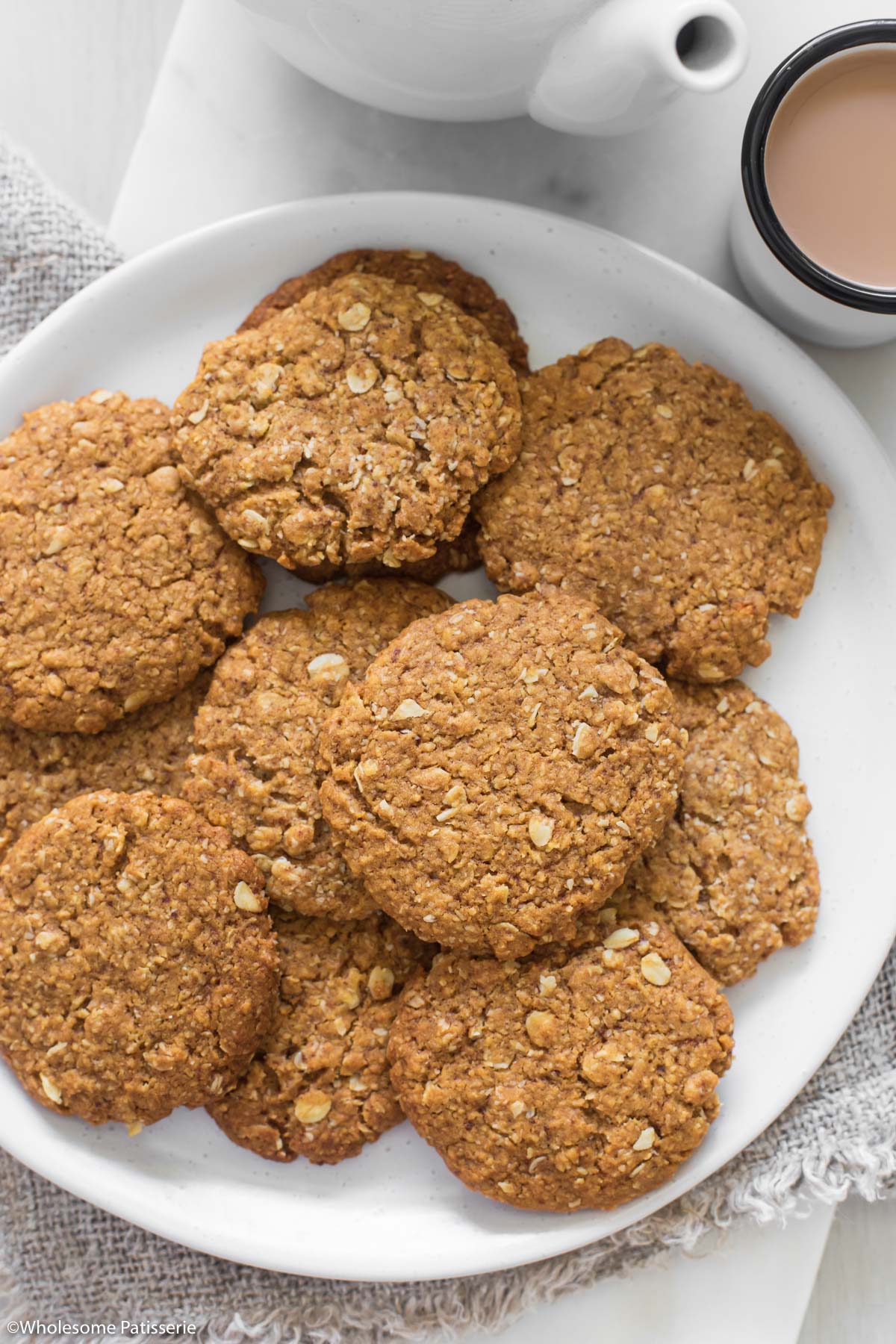 Healthy Anzac biscuits sitting on a white plate.