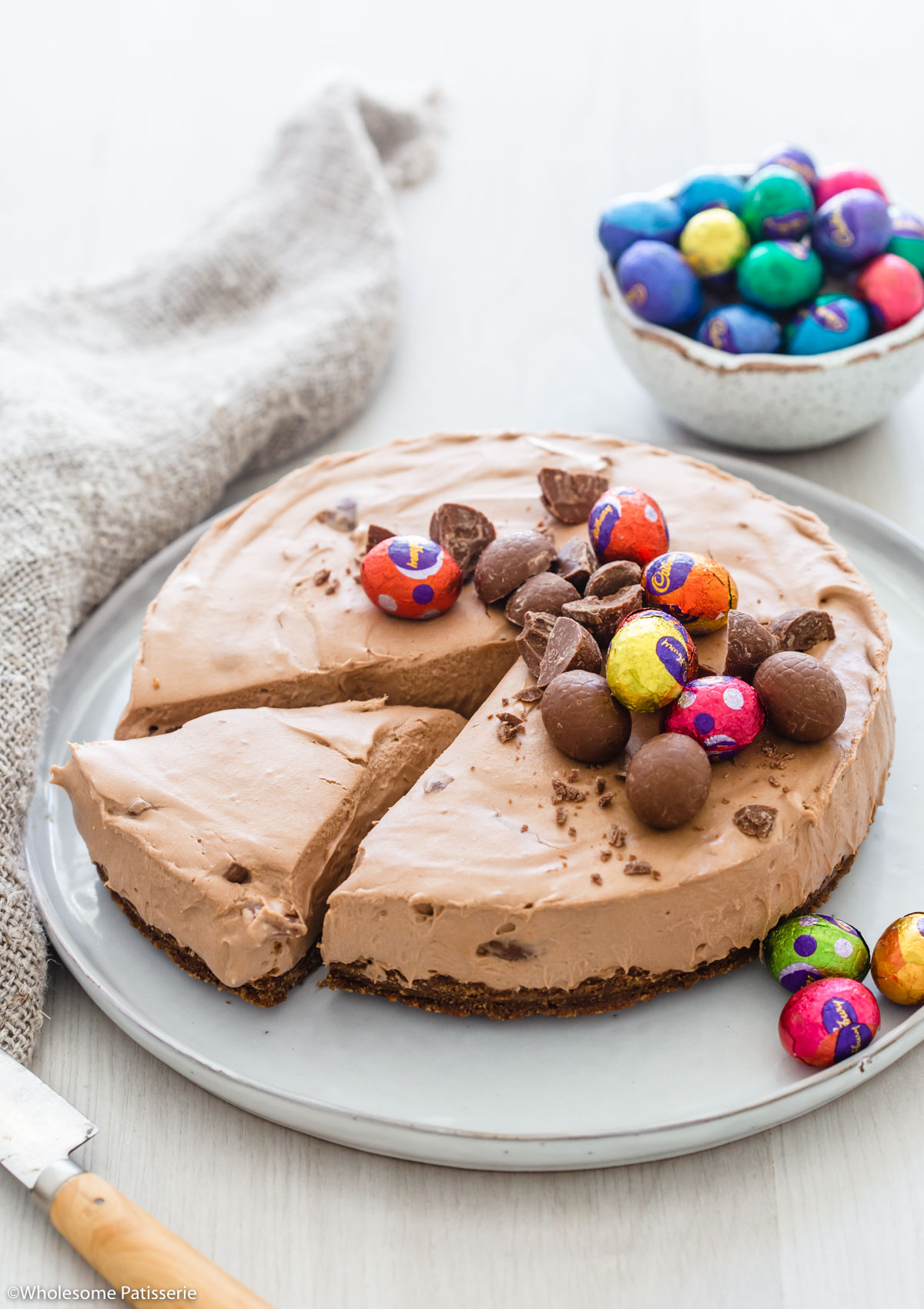 No Bake Easter Egg Nutella Cheesecake on plate decorated with small Easter eggs.
