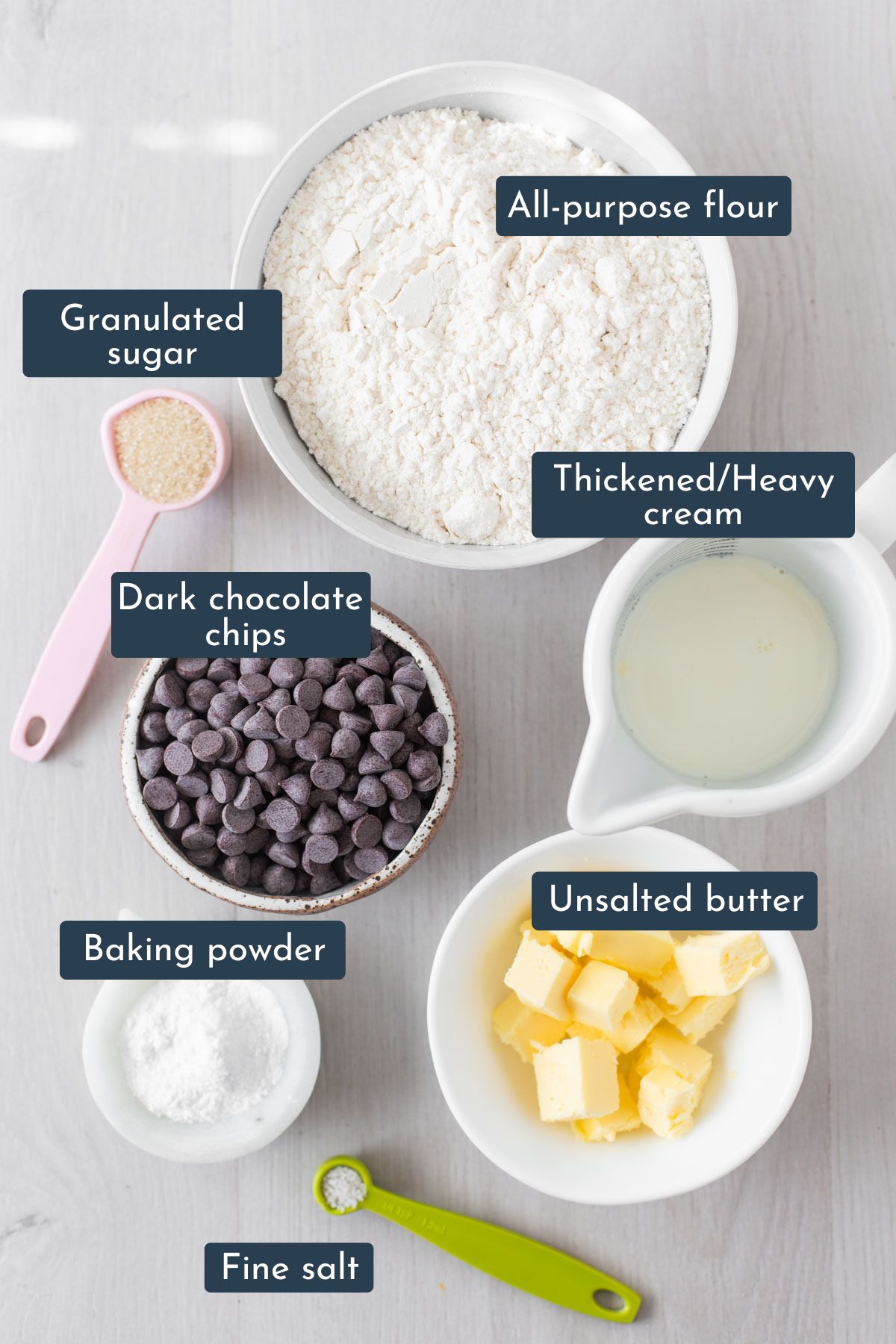 Ingredients to make chocolate chips scones is all-purpose flour, unsalted butter, baking powder, salt, granulated sugar, thickened cream and dark chocolate chips.