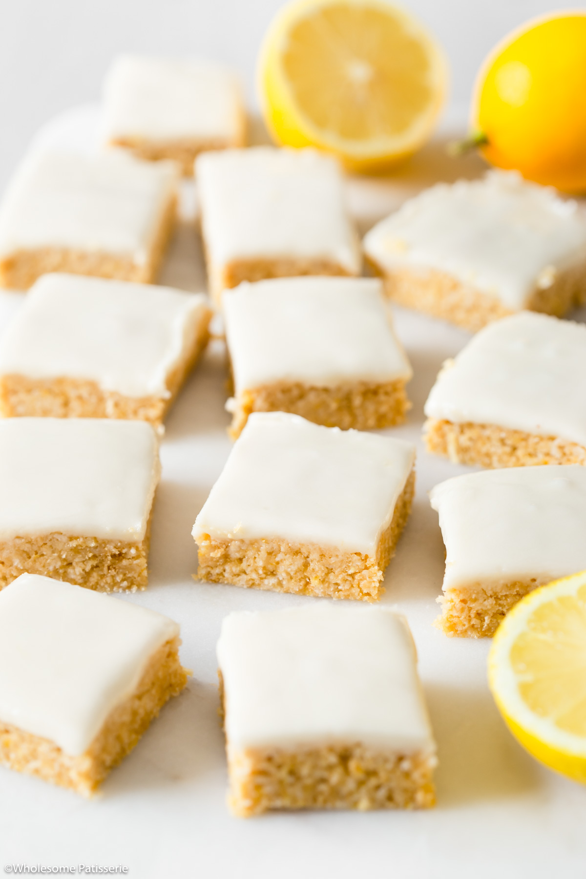 Slices of vegan lemon slice displayed on marble platter next to slices of fresh lemon