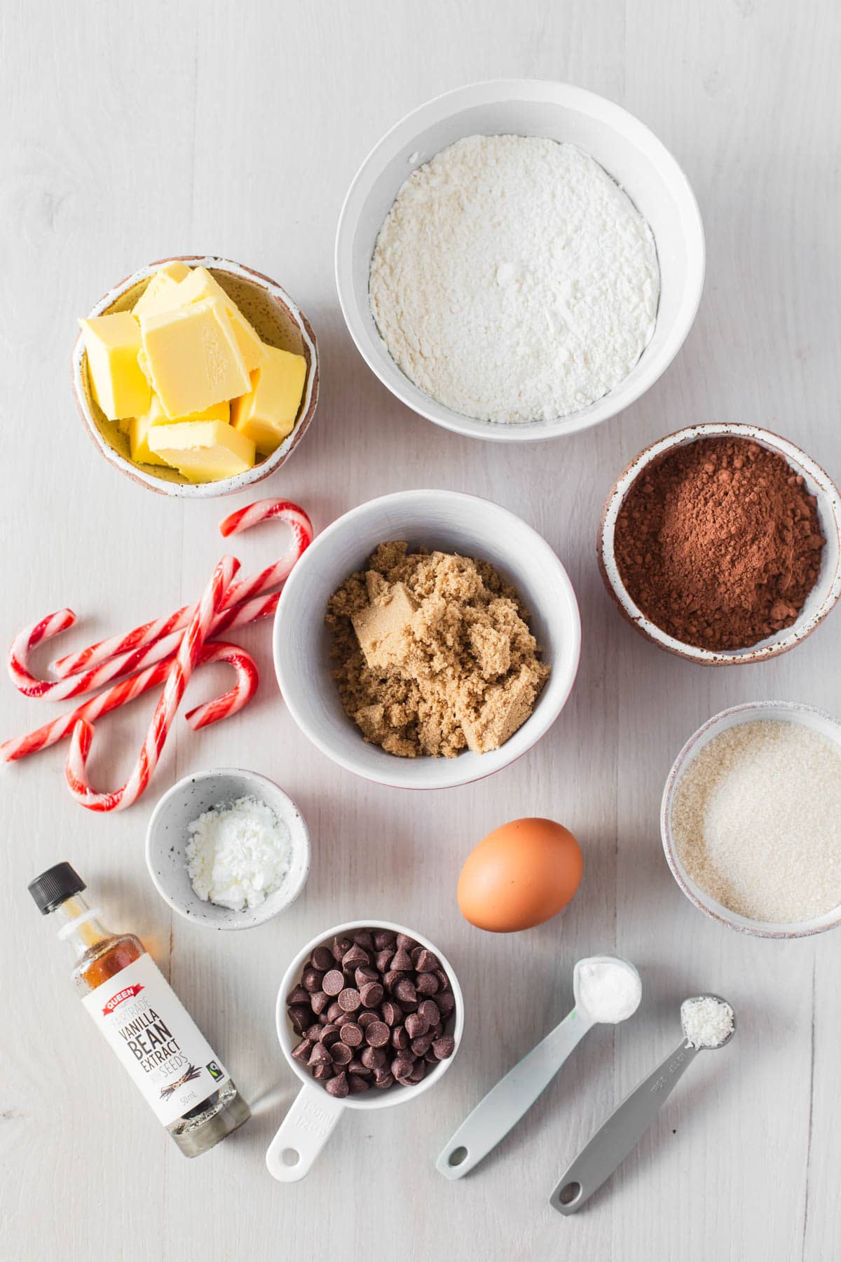 Ingredients to make chocolate peppermint cookies on white backdrop.