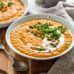 Pumpkin sweet potato soup in bowl with garnishes.
