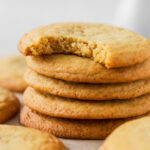 Soft and chewy chocolate chipless cookies in a cookie stack with a bite taken out of the top one.