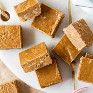 Gingerbread white chocolate fudge cut into squares and displayed on platter.