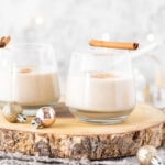 Christmas eggnog in glasses next to small baubles.