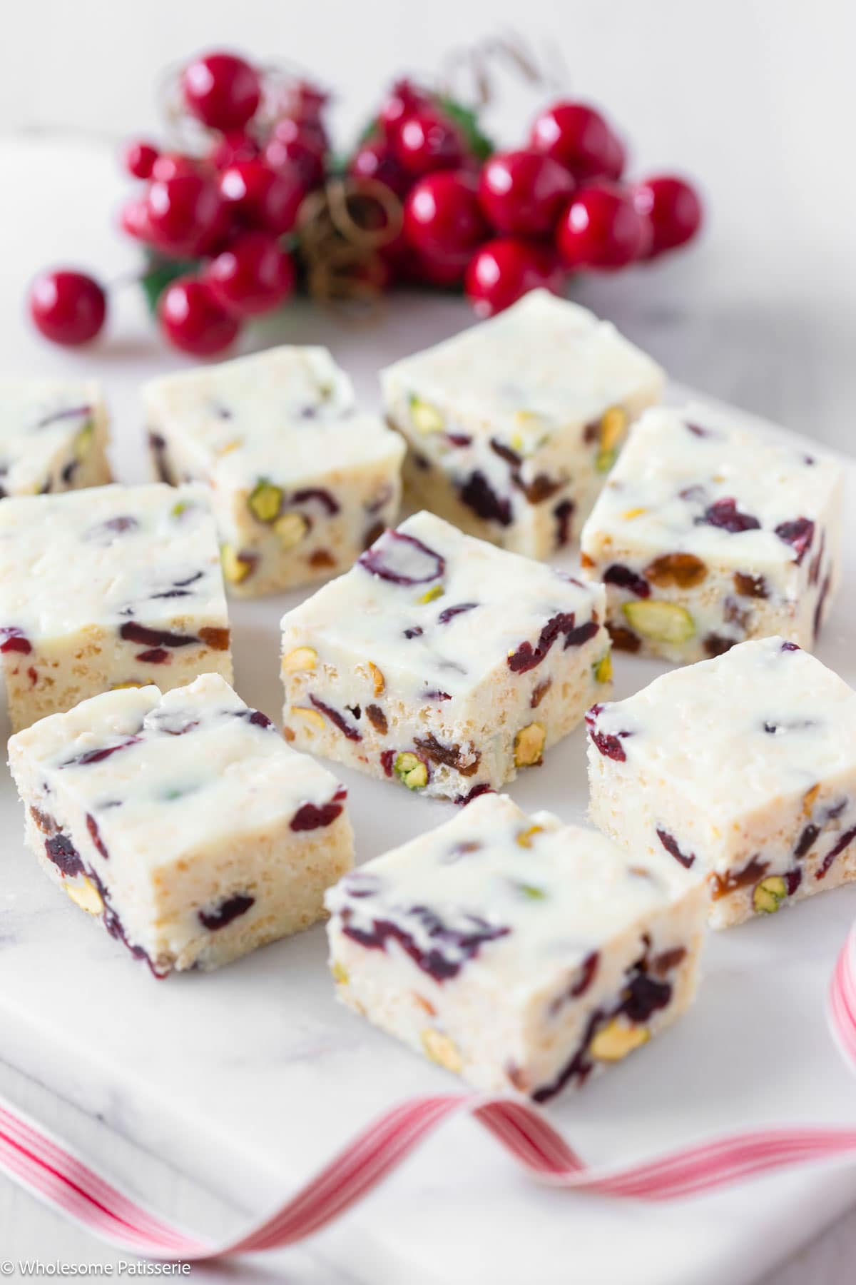 White christmas slice with condensed milk cut into squares and displayed on white platter.