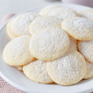 Vanilla meltaway cookies sitting on plate dusted with powdered sugar.