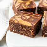 Almond brownies sliced and displayed on marble platter.