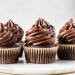 Classic chocolate cupcakes sitting on marble board.