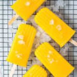 Pineapple mango icy poles on wire rack sitting on crushed ice.