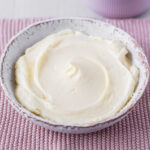 Cream cheese frosting in small bowl.