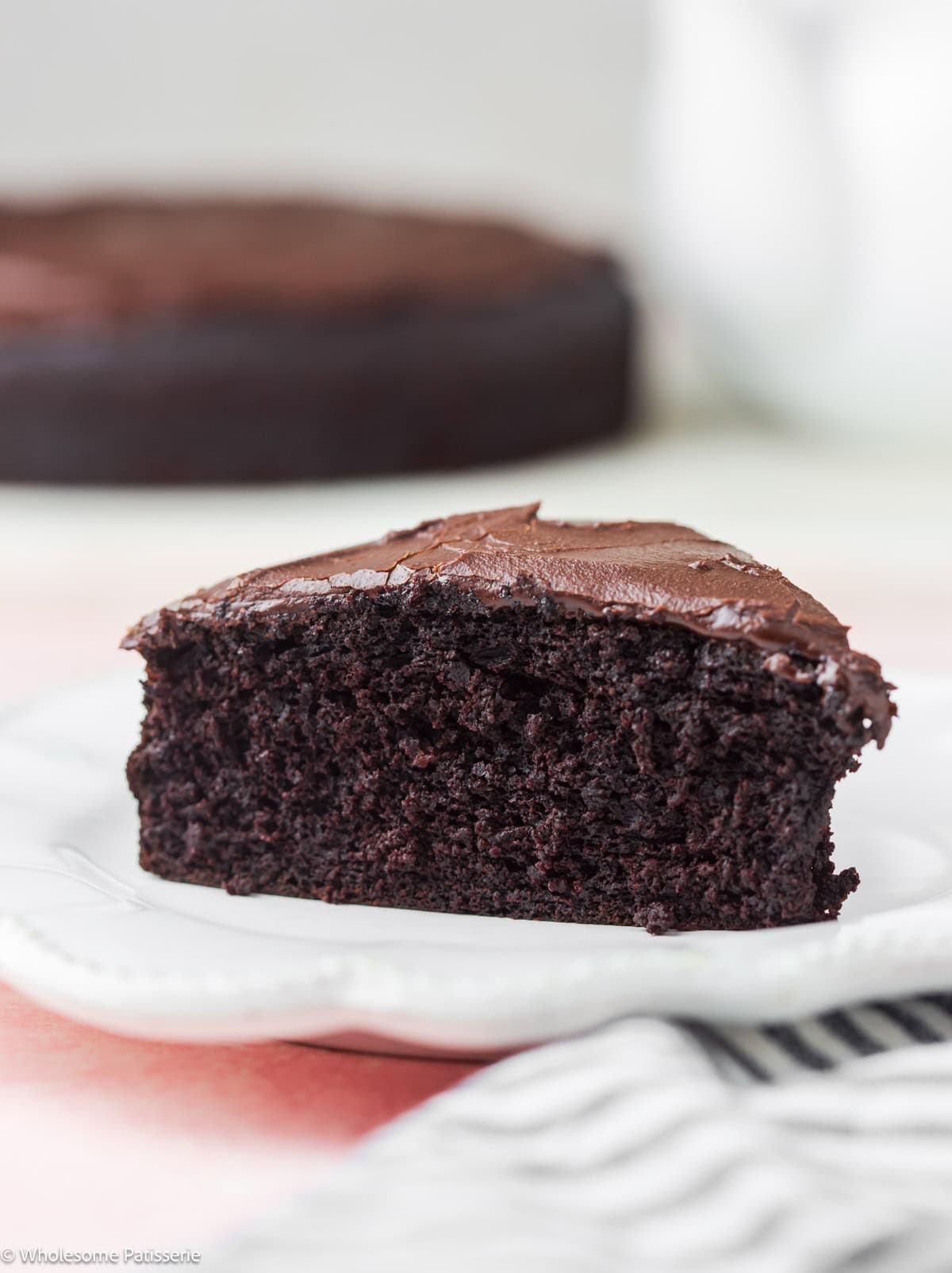 Slice of eggless chocolate cake on plate.