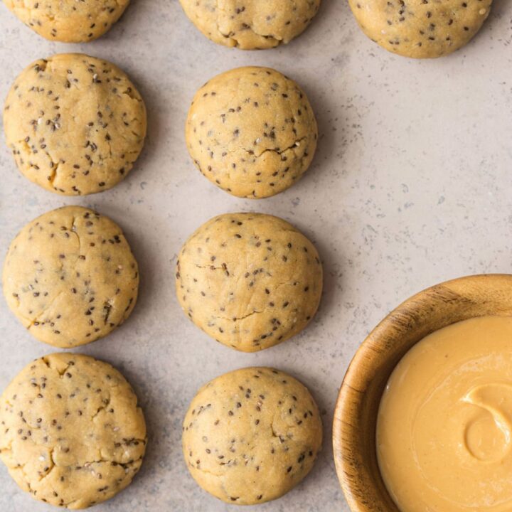Chia seed cookies next to bowl of peanut butter.