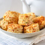 Savory cheese, chive and ham scones in bowl.