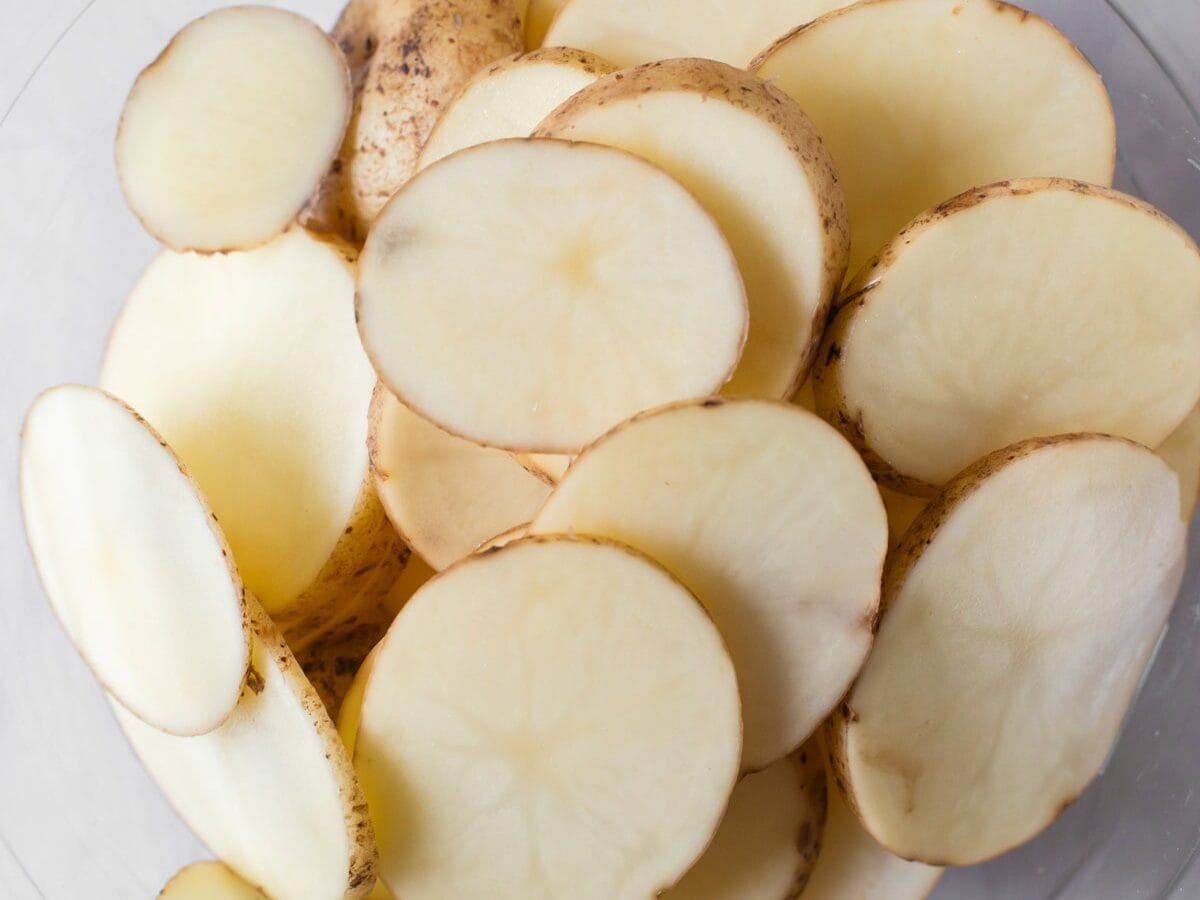 Sliced potatoes in bowl.