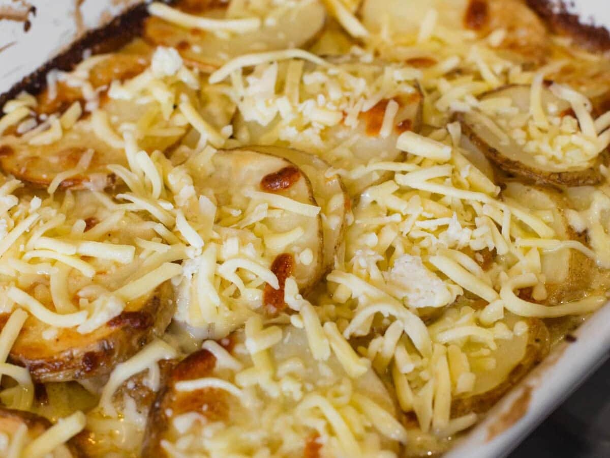 Sprinkling remaining cheese over easy potato bake.