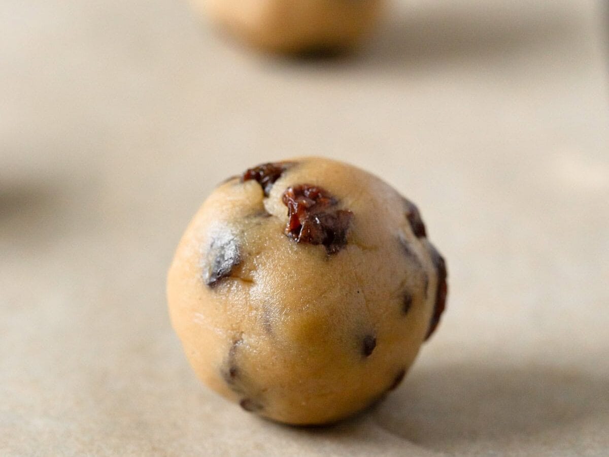 Sultana cookie dough ball on baking sheet not flattened.