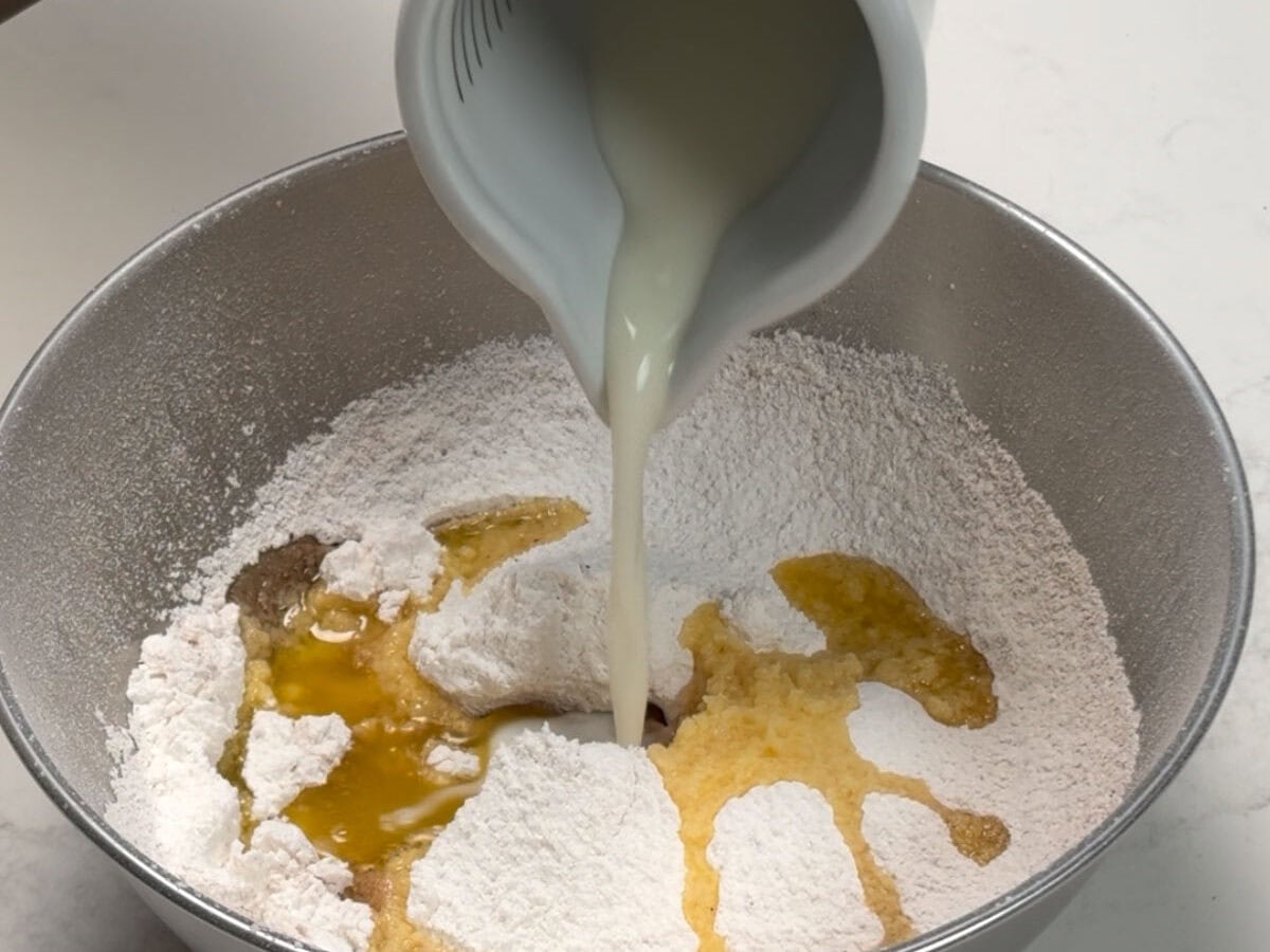 Pouring milk and butter into the sifted powdered sugar mixture.