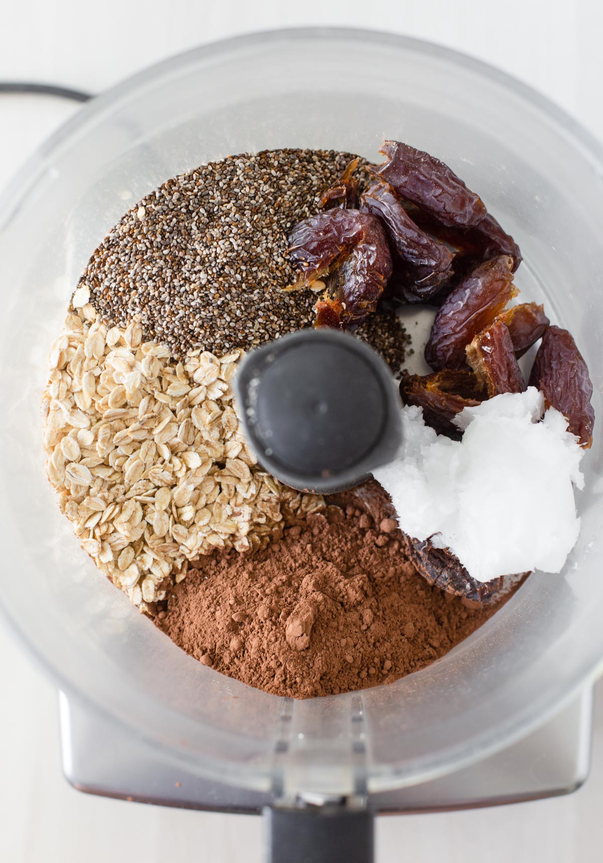 Ingredients to make chia seed bliss balls in food processor.