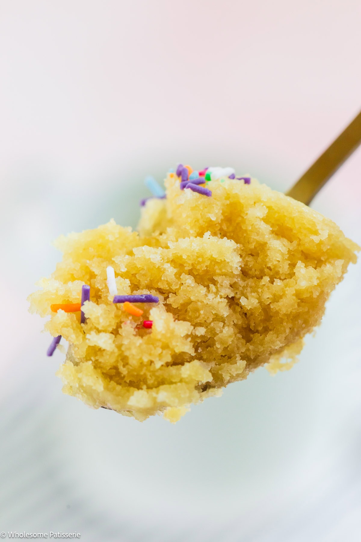 No milk vanilla mug cake on spoon ready to eat.