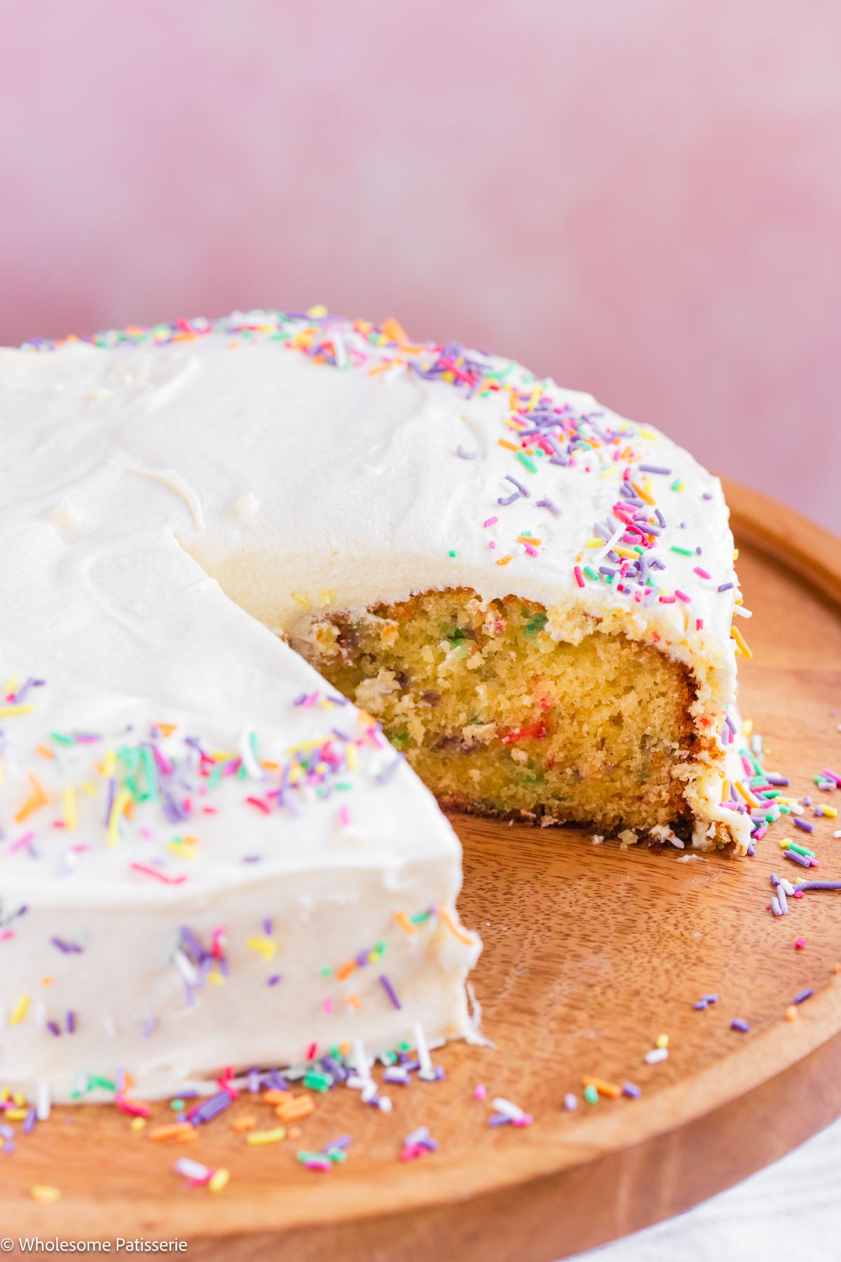Slice removed from one layer birthday cake on cake stand.