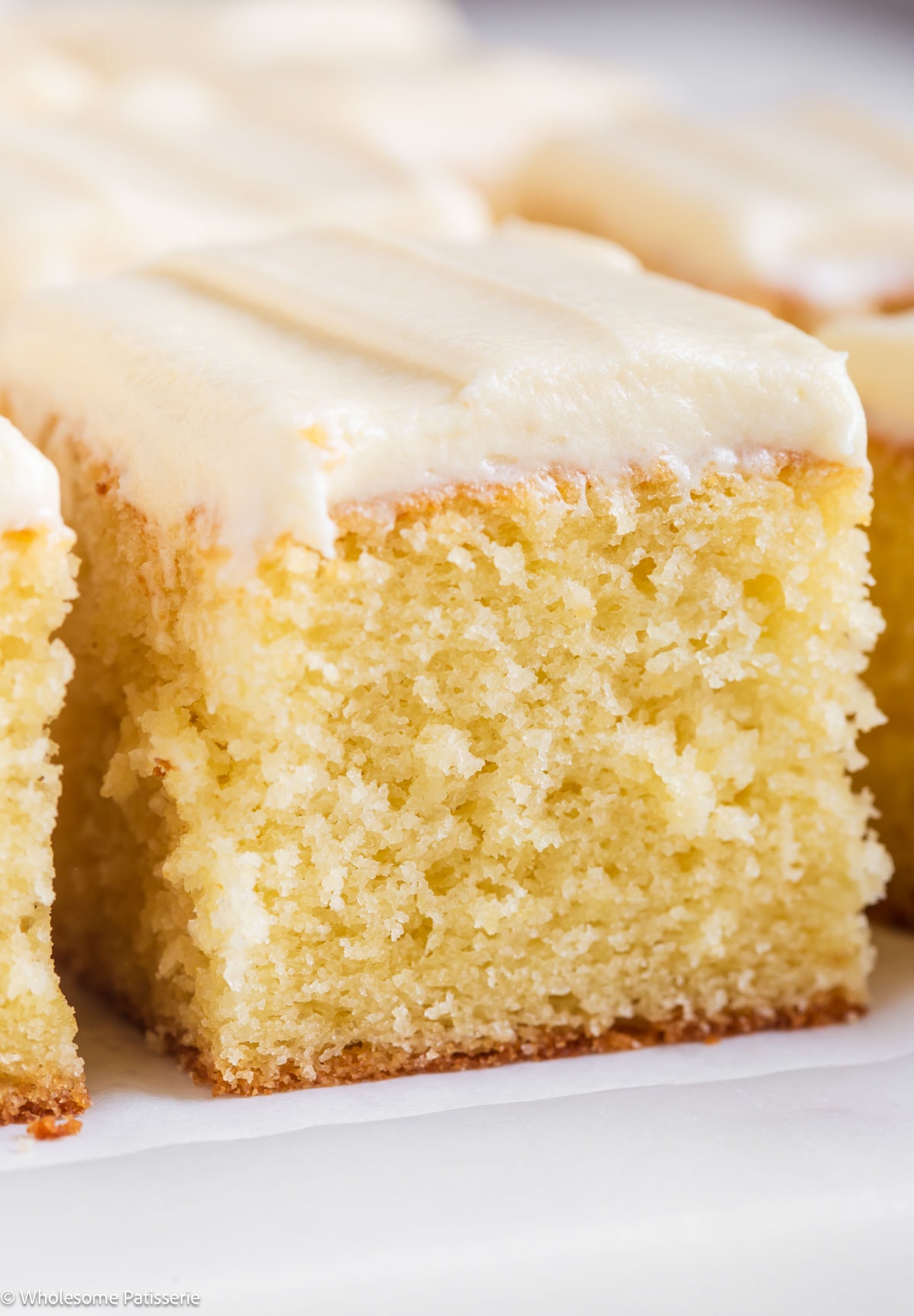 Slice of vanilla cake without vanilla extract with cream cheese frosting.