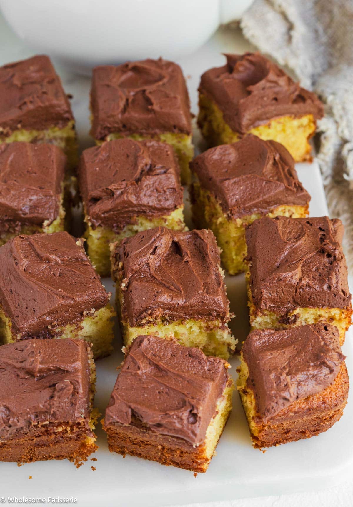 One Layer Yellow cake without buttermilk cut into squares displayed on marble board.