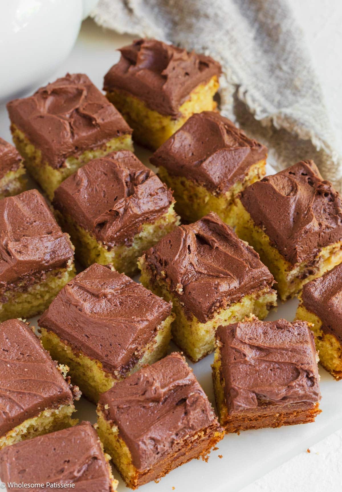 One Layer Yellow cake without buttermilk cut into squares displayed on marble board.