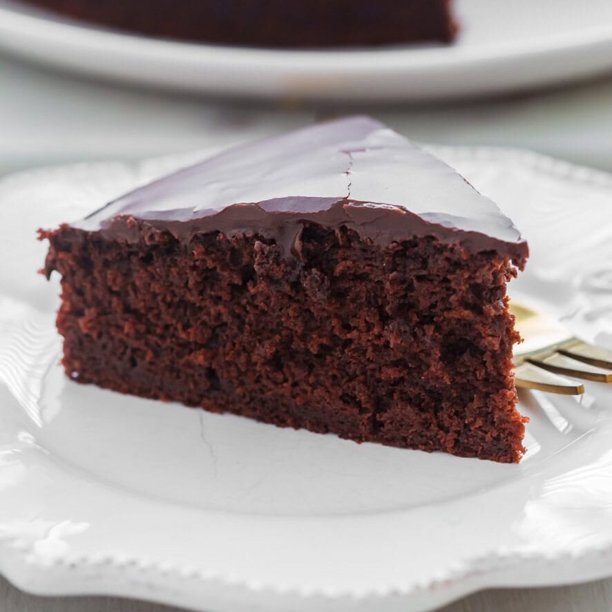 Slice of chocolate cake without milk on white plate.