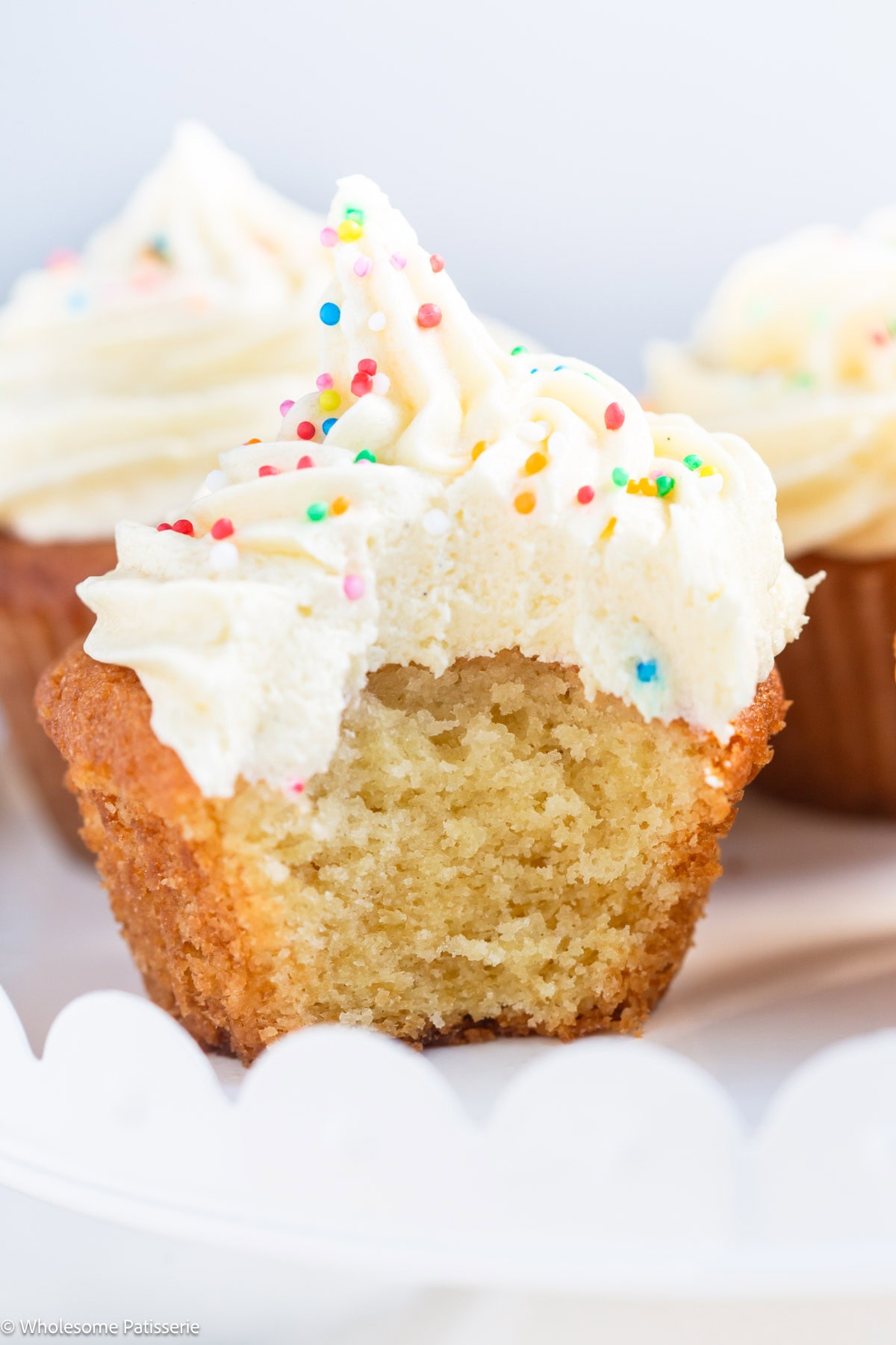 Vanilla cupcake without milk with bite taken out and with frosting.
