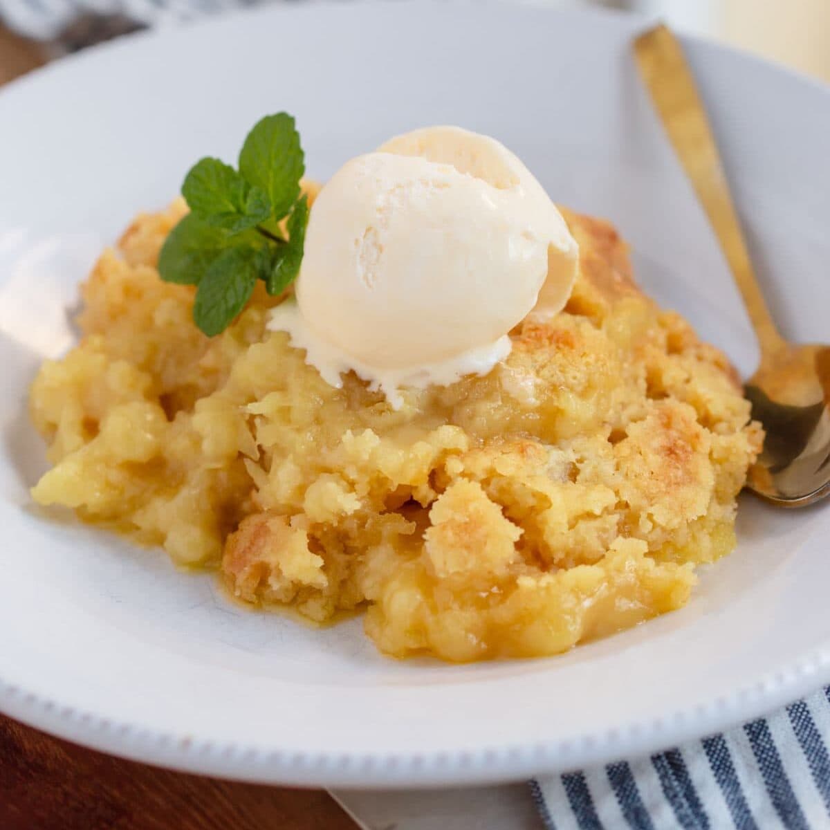 Easy pineapple dump cake without cake mix served with ice cream.