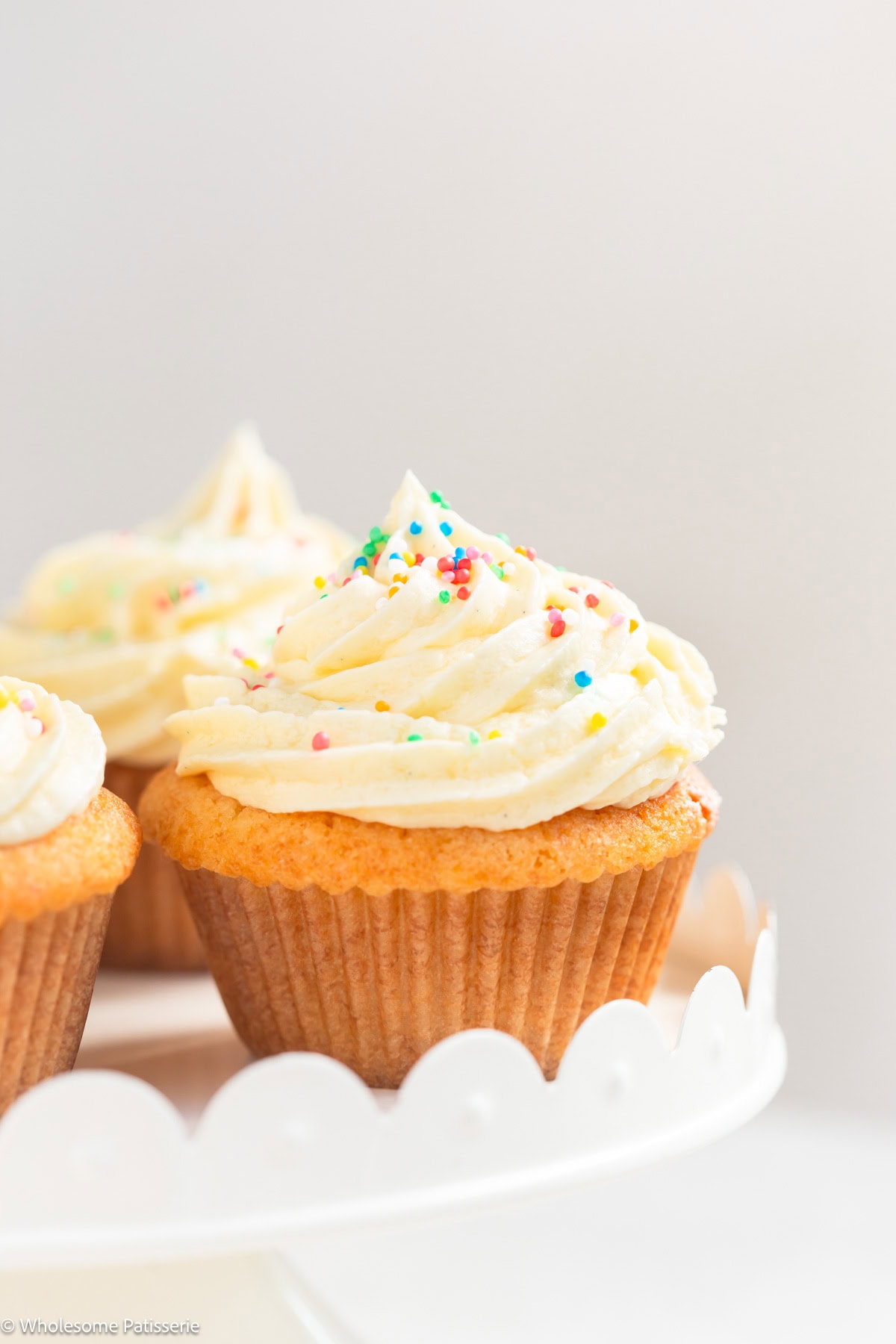 Vanilla cupcake without milk with frosting on cake stand.