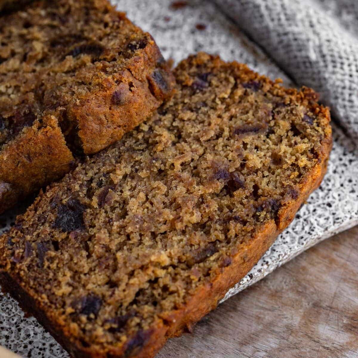 A loaf of sugar free date bread with a knife on a cloth
